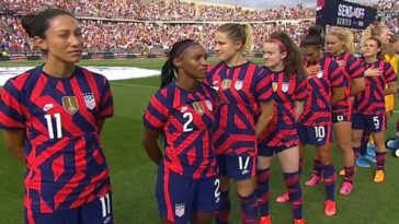U.S. soccer players walk away from national anthem being played by World War II veteran