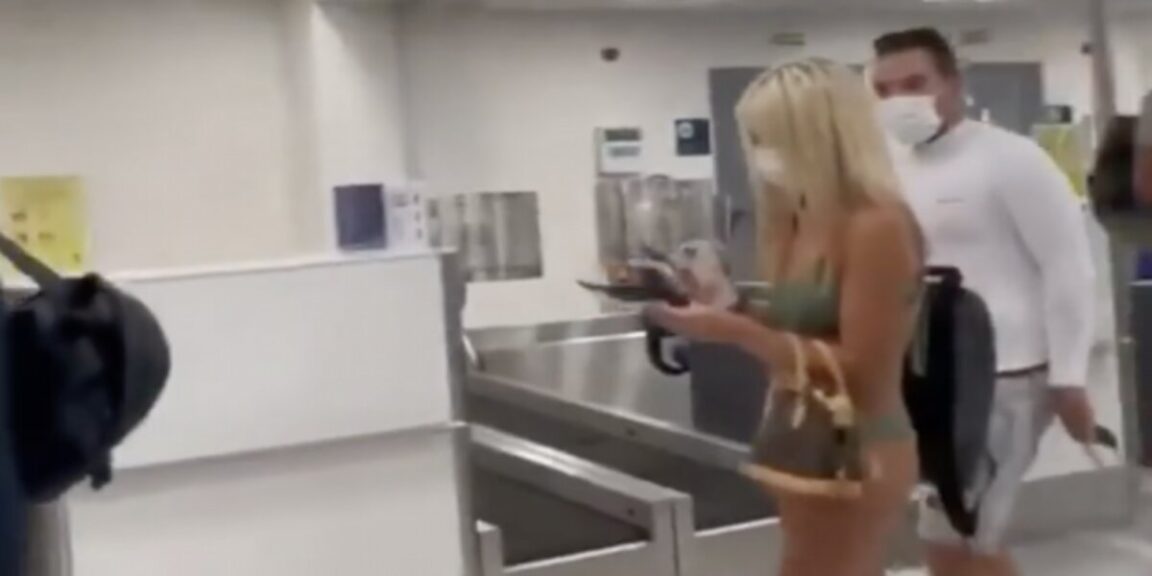 Woman walks through airport clad only in a bikini and a facemask