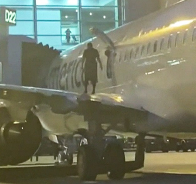 An American Airlines passenger opens the emergency exit and jumps onto the plane's wing in Miami