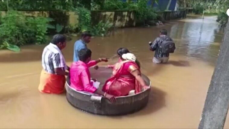 Desperate to get married, Indian couple floats in large pot to reach their wedding after flooding